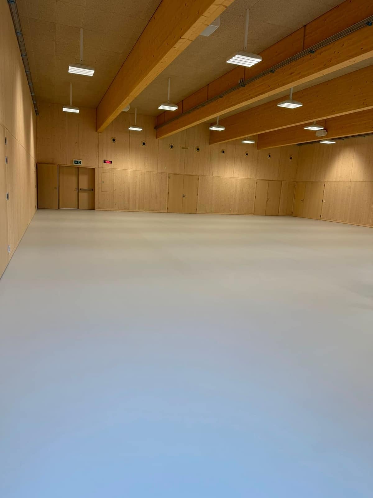 Mehrzwecksaal mit Holzdecke nach der Bauendreinigung durch Imeri Reinigung