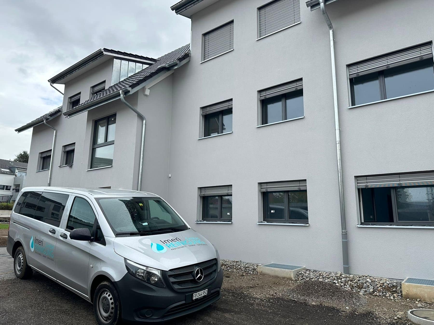 Firmenfahrzeug von Imeri Reinigung vor einem Mehrfamilienhaus