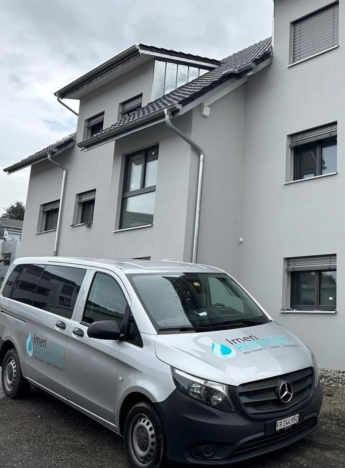 Firmenfahrzeug von Imeri Reinigung vor einem Mehrfamilienhaus