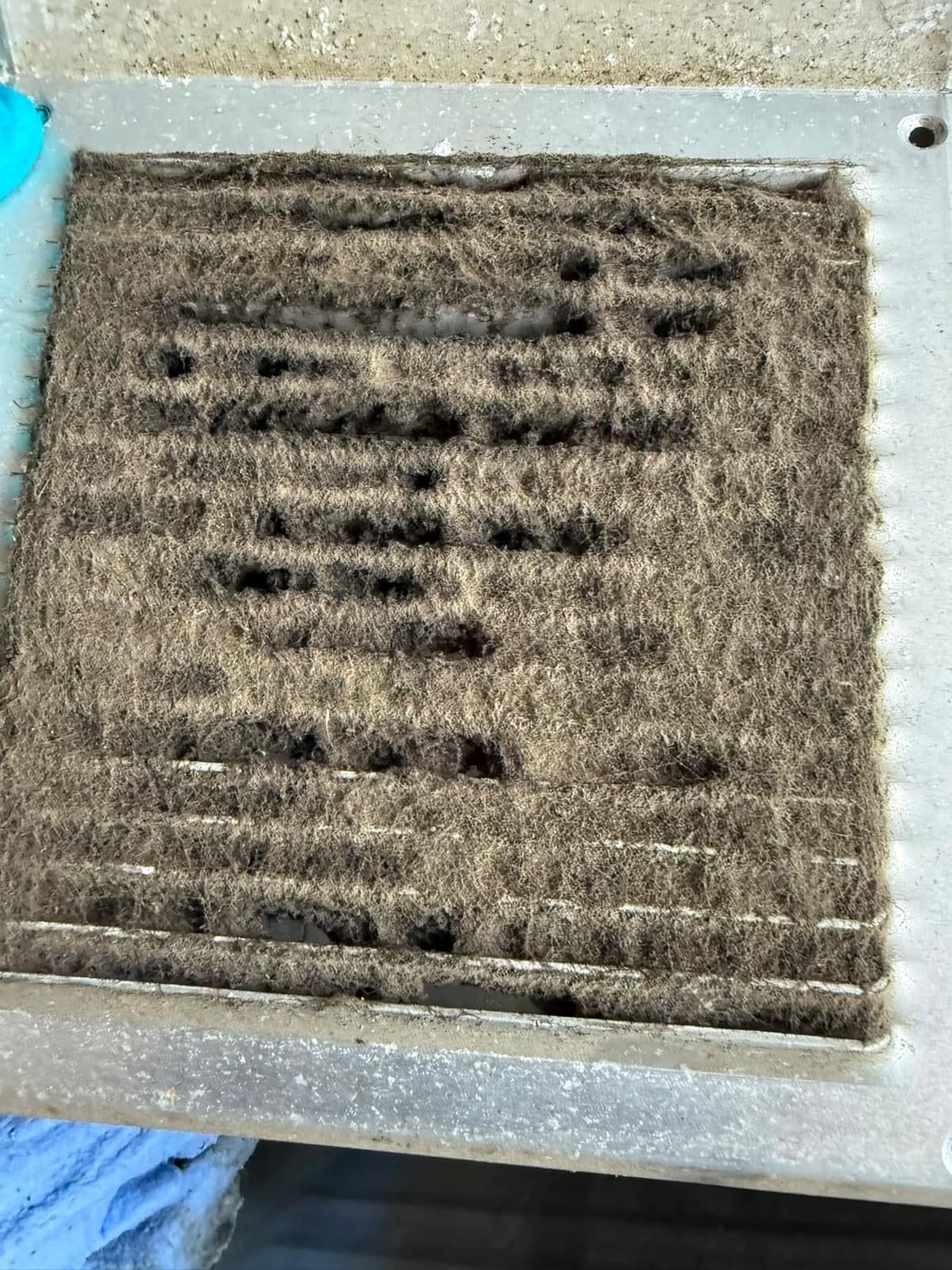 Ausgebautes Lüftungsgitter mit Staubbelag vor der Reinigung