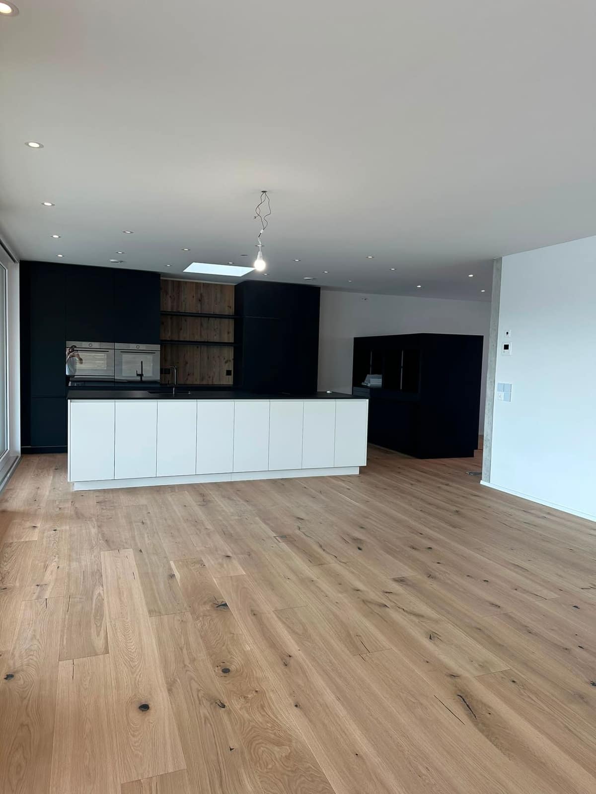 Leere Wohnung mit Kochinsel, übergabefertig gereinigt